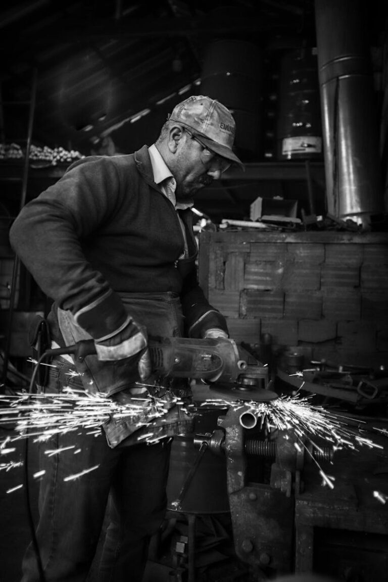 Industrial metalworker creating sparks while grinding in a workshop.